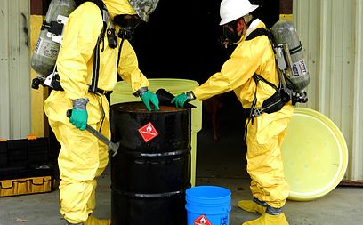 environmental technicians overpacking a leaking drum
