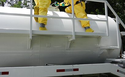 Technicians inspect the hatch on a leaking railcar